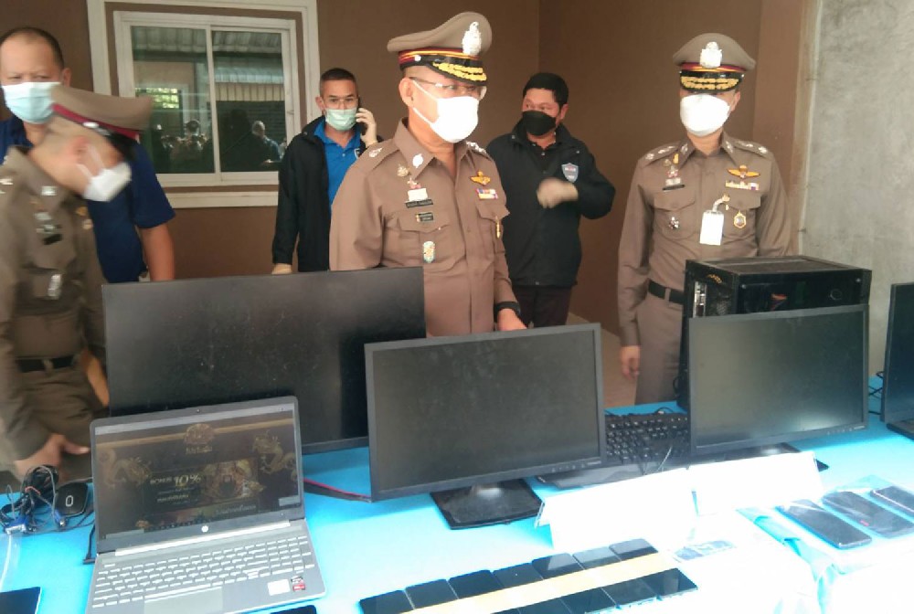 Police inspect seized computers and other devices after a raid on a house in Muang district of Nakhon Sawan that served as an online gambling hub. (Photo: Chalit Pumruang)